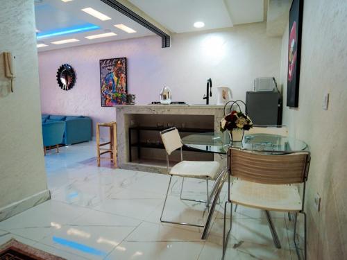 une salle à manger avec une table et des chaises en verre dans l'établissement home away from home 2 bedroom luxury apartment gulize, à Marrakech