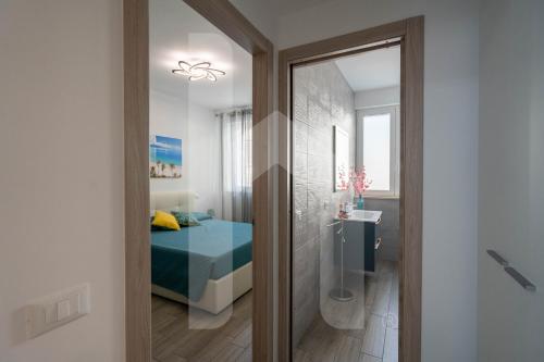 ein Schlafzimmer mit Bett und ein Badezimmer mit Spiegel in der Unterkunft Homiday - Stella Del Mare in Alba Adriatica