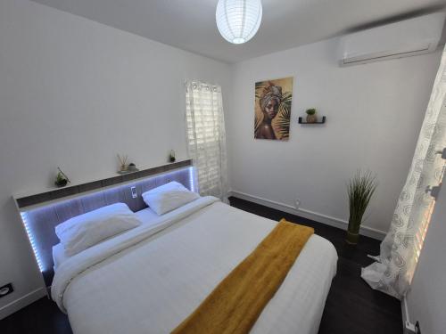 a bedroom with a large white bed in a room at Sensalys in Sainte-Rose