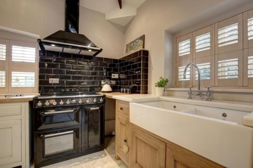 a kitchen with a sink and a stove at The Foundry in Burnham Market