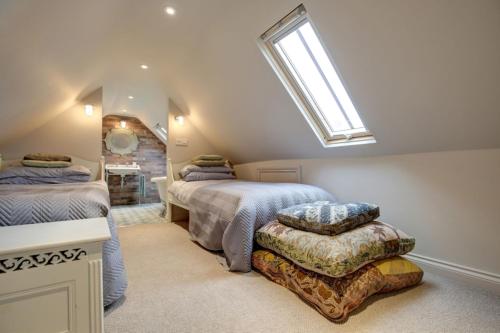 a attic bedroom with two beds and a skylight at The Foundry in Burnham Market