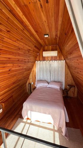 ein Bett in einem Zimmer mit Holzdecke in der Unterkunft Chale Pedra do Sol in Caxias do Sul