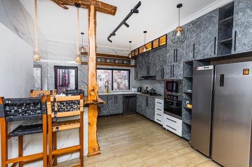 eine Küche mit Küchengeräten aus Edelstahl und Holzbalken in der Unterkunft The Crest Apartment in Kigali