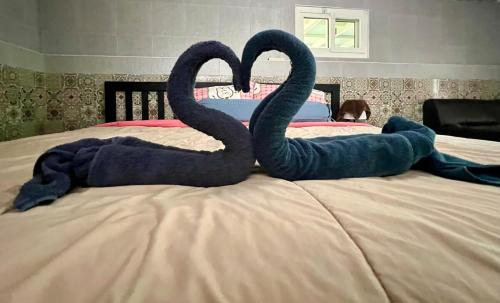 a child laying on a bed with two swans at House&Spa in Koh Phangan