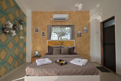 a bedroom with a bed with two towels on it at ll EMPYREAN STAY ll VALENTINA VILLA ll 2BHK ll AC ll PRIVATE POOL ll in Lonavala