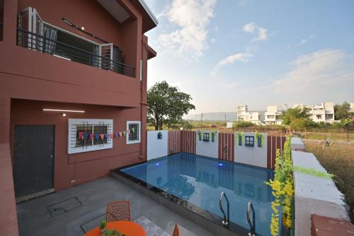 a house with a swimming pool next to a building at ll EMPYREAN STAY ll VALENTINA VILLA ll 2BHK ll AC ll PRIVATE POOL ll in Lonavala