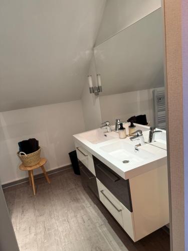Un baño blanco con dos lavabos y un espejo. en Appartement Le Belarya, en Wintzenheim