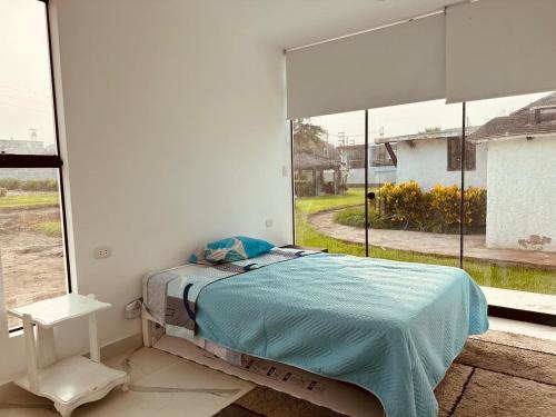 a bedroom with a bed and a large window at Casa Playa en Aucallama Beach Club in Aucallama