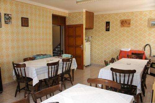 a dining room with tables and chairs and a kitchen at Apartments and rooms with parking space Palit, Rab - 3195 in Rab