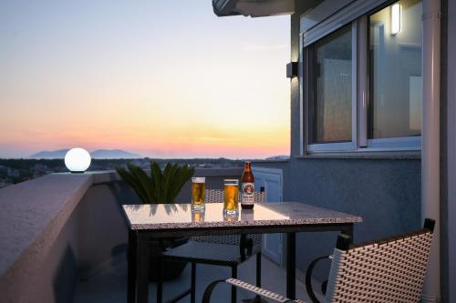 a table on a balcony with two bottles of beer at Queen Apartmets Vlore in Vlorë