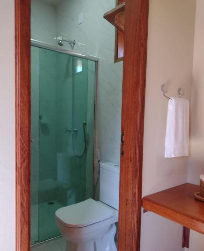 a bathroom with a toilet and a glass shower at Pousada Vila Madeira in Sítio Selva de Pedra