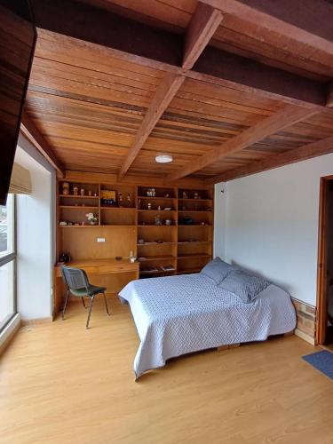 a bedroom with a bed and a chair in it at Casa Café & Orquídea - Hospedaje in Bogotá