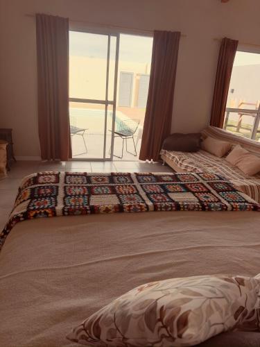 a bedroom with two beds and a view of a balcony at La curva in Ramallo