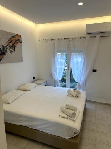 a bedroom with a bed with white sheets and a window at Athos studio in Análipsis