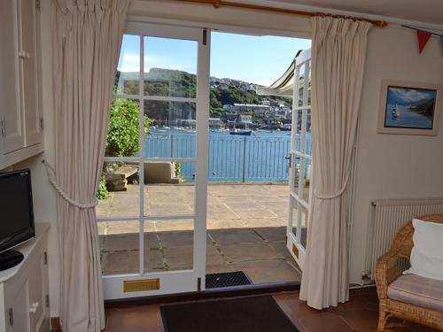 een woonkamer met een deur naar een patio bij Roadstead in Fowey