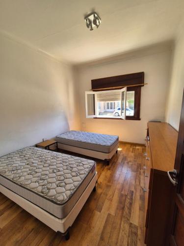 a room with two beds and a window at Las Gonzalez in Olavarría