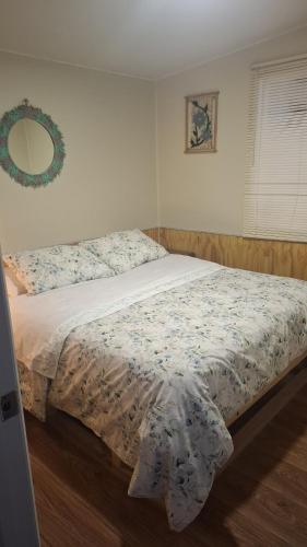 a bedroom with a bed with a floral bedspread on it at CABAÑA OSORNO Ruta 215 in Osorno