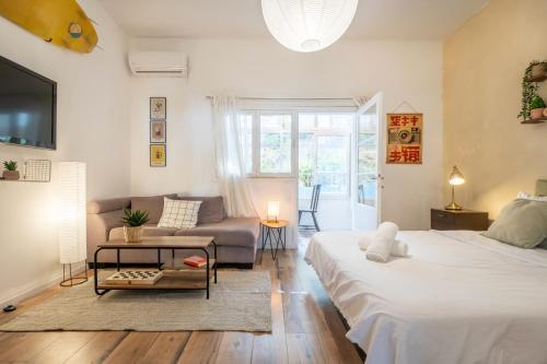 ein Wohnzimmer mit zwei Betten und einer Couch in der Unterkunft Carmel Emerald in Haifa