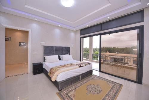 ein Schlafzimmer mit großem Bett und Balkon in der Unterkunft Villa Route de Fes in Marrakesh in Douar bel Rhanodour