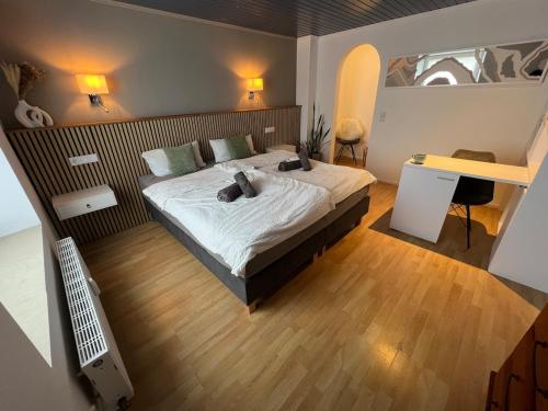 ein Schlafzimmer mit einem großen Bett und einem Schreibtisch in der Unterkunft Little Rose - modern, central with WiFi & parking in Bad Sobernheim