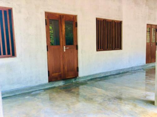 Un par de puertas de madera en un edificio con agua en Thalpathwewa Cave Temple, 