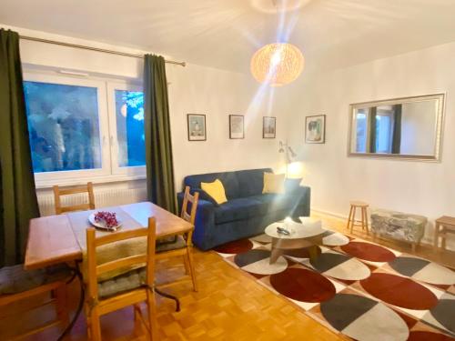 a living room with a blue couch and a table at Appart 2parkings, 2min PetiteVenise-Xmarché in Colmar
