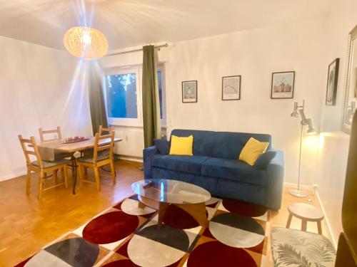 a living room with a blue couch and a table at Appart 2parkings, 2min PetiteVenise-Xmarché in Colmar