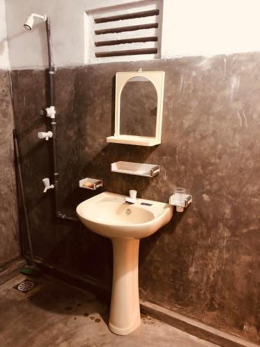 a bathroom with a sink and a mirror at Thalpathwewa Cave Temple in Kaduruwewa