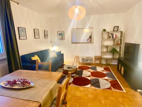 a living room with a table and a room with a couch at Appart 2parkings, 2min PetiteVenise-Xmarché in Colmar