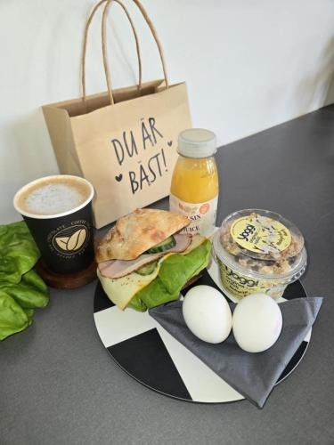 Motellet Karlskrona في كارلسكرونا: صحن مع ساندويتش وبيض وكوب من القهوة