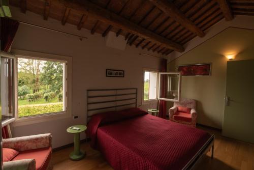Un dormitorio con una cama roja y una ventana. en Azienda Vitivinicola Ca' Manin, en Vo Euganeo