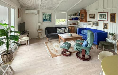 Una sala de estar con un sofá azul y una mesa. en 3 Bedroom Gorgeous Home In Assens, en Assens