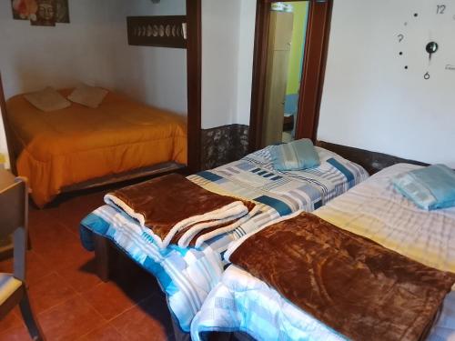 two beds in a room with a mirror at Alojamiento Neres in Salto