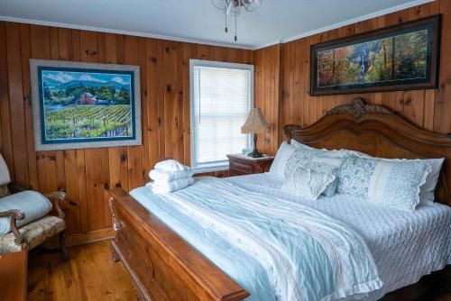 ダロネガにあるDahlonega Inn on Mainの木製の壁のベッドルーム1室(大型ベッド1台付)