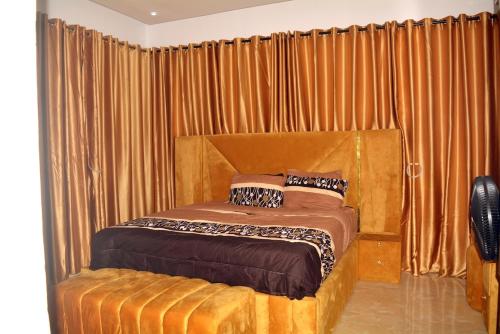 una camera con letto in legno e tende di Posh Modern Ikeja 2 Bedroom a Ikeja