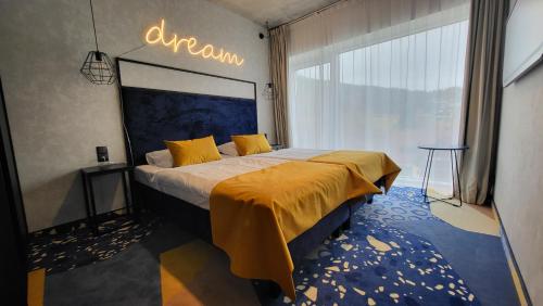 ein Schlafzimmer mit einem Bett mit gelber Bettwäsche und einem großen Fenster in der Unterkunft Apartament Słoneczny z aneksem Biała Perła Czarna Góra in Heudorf
