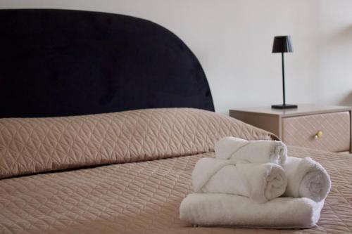 een stapel handdoeken bovenop een bed bij Sostal5 in Chiubbica
