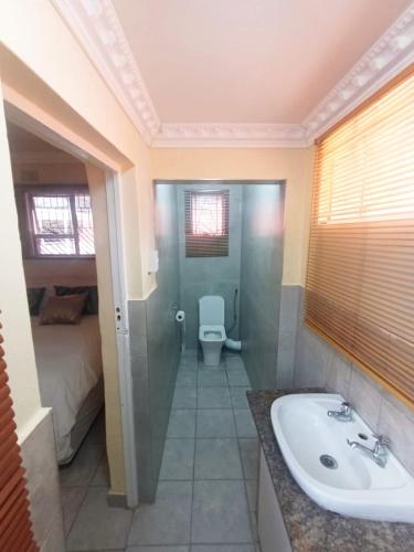 a bathroom with a sink and a toilet in a room at Sweet Home B & B in East London