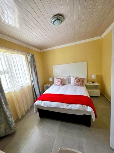 a bedroom with a large bed with a red blanket at Sweet Home B & B in East London