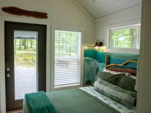 une chambre avec un lit et une porte coulissante en verre dans l'établissement 3 Homes on Blueberry Farm - Waterfall, Game Room, à Mentone