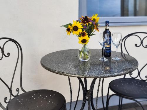 una mesa con un jarrón de flores y una botella de vino en The Nook, en Portishead