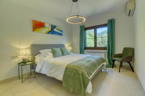 a bedroom with a bed and a chair and a window at Best Views in Valldemossa in Valldemossa