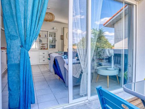 a kitchen with a sliding glass door to a patio at Charmant T2 avec terrasse, climatisation et WIFI - Quartier résidentiel à Biscarrosse - FR-1-521-217 in Biscarrosse