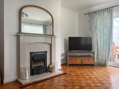 a living room with a fireplace and a television at Springfield Bungalow in Cliftonville