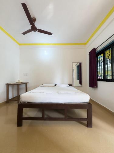 a bed in a room with a ceiling fan at IVON Guest House Arambol in Arambol