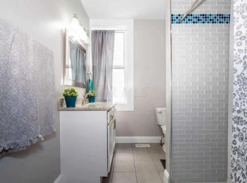 a white bathroom with a sink and a toilet at Jungle House Columbus Downtown Free Parking Sleeps 8 - Near Convention Center & Nationwide Arena - 2BR Short North Luxury Home - Over 5,800 Five Star Stays in Columbus