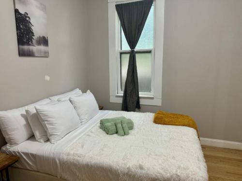 a white bed with a green stuffed animal on it at Jungle House Columbus Downtown Free Parking Sleeps 8 - Near Convention Center & Nationwide Arena - 2BR Short North Luxury Home - Over 5,800 Five Star Stays in Columbus