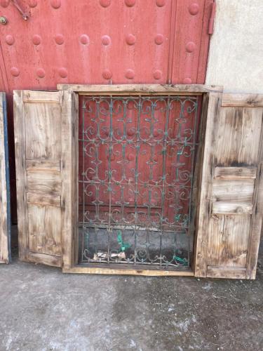a wooden door with a metal grate on it at AISHAMA Healing House in Aït Ourir