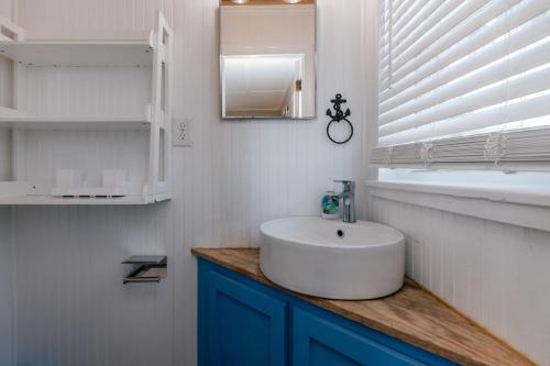 een witte badkamer met een wastafel en een raam bij Beach Retreat in Edisto Island