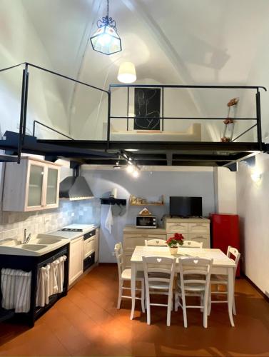 een keuken met een eettafel en een hoogslaper bij Perugia Historic center house in Perugia